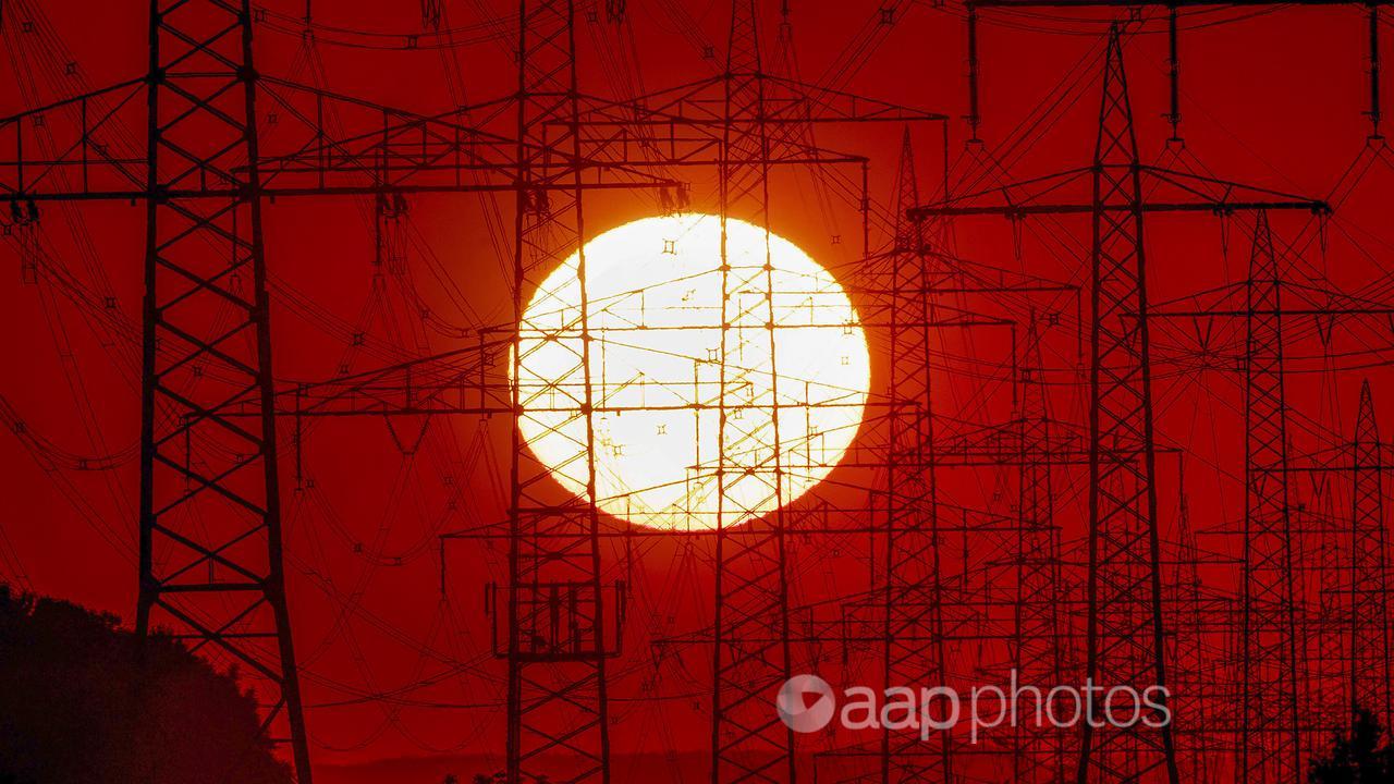 The sun rises behind power poles in Germany