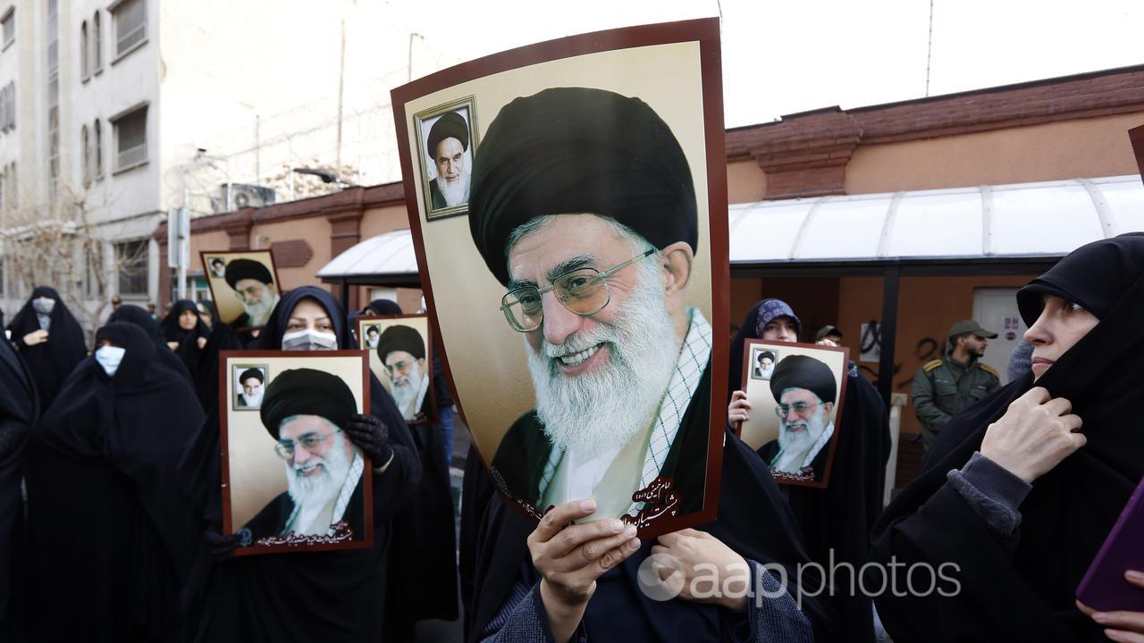 Women hold pictures of Iran Supreme Leader Ayatollah Khamenei